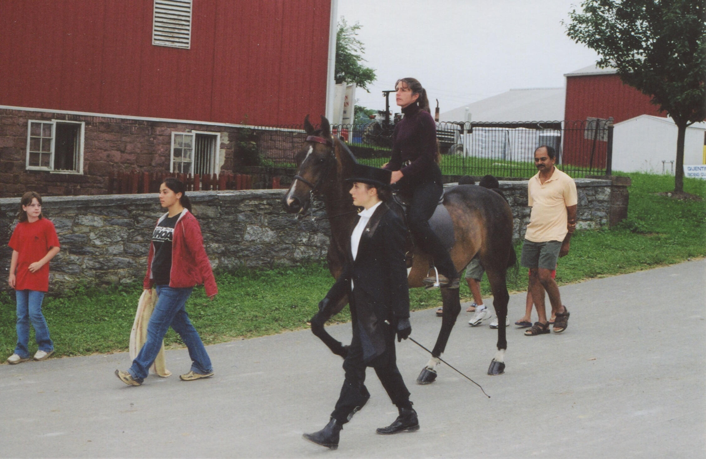 Horse show class at Quentin Riding Club during its golden era, with a rider mounted on horseback led past the historic barns